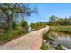 Picturesque walking path beside a stream with lush greenery and clear blue sky at 1335 S Holly St, Denver, CO 80222