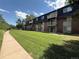 Well-maintained brick apartment building with balconies overlooking manicured lawn and a walking path at 309 E Highline Cir # 102, Centennial, CO 80122