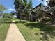 Brick apartment building featuring private balconies surrounded by mature trees and a sidewalk at 309 E Highline Cir # 102, Centennial, CO 80122