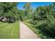 Concrete walking path through lush green grass and vibrant trees at 309 E Highline Cir # 102, Centennial, CO 80122