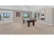 Basement entertainment room features a pool table, large windows, and ample space at 6860 S Yantley Ct, Aurora, CO 80016