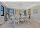 Elegant dining room with a large table, white chairs, tray ceiling, and scenic views through the windows at 6860 S Yantley Ct, Aurora, CO 80016