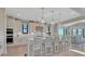 Bright kitchen with white cabinets, a large island with seating, and modern pendant lighting at 6860 S Yantley Ct, Aurora, CO 80016