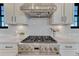 Close-up of a high-end stainless steel range with a white backsplash and modern cabinetry at 6860 S Yantley Ct, Aurora, CO 80016