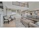 Open concept living room featuring a large sectional sofa, modern staircase, and adjacent kitchen at 6860 S Yantley Ct, Aurora, CO 80016