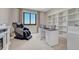 Bright home office with a sleek desk, comfortable massage chair, and custom built-in shelving and storage at 6860 S Yantley Ct, Aurora, CO 80016