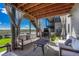 Covered outdoor patio area with lounge seating, a fireplace, and a scenic view at 6860 S Yantley Ct, Aurora, CO 80016