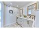 Bright bathroom with double vanity, and wood-framed mirrors at 8167 S Wabash Ct, Centennial, CO 80112