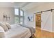 Bright main bedroom featuring an ensuite bathroom with sliding barn door entry at 8167 S Wabash Ct, Centennial, CO 80112