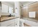 Bathroom with granite countertop vanity, stylish fixtures, and a shower-tub combination with sliding glass doors at 2645 S Xanadu Way # C, Aurora, CO 80014