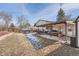 Landscaped backyard features a covered patio with outdoor seating, a shed, and a fenced perimeter at 15341 E Arkansas Pl, Aurora, CO 80017