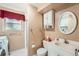 Well-lit bathroom featuring a white vanity, a medicine cabinet, and a shower with maroon curtain at 15341 E Arkansas Pl, Aurora, CO 80017