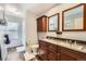 Bathroom featuring a dual vanity with wood cabinets and shower with patterned floors at 15341 E Arkansas Pl, Aurora, CO 80017