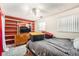 Cozy bedroom with built-in shelving, dresser, and a comfortable bed with gray patterned bedding at 15341 E Arkansas Pl, Aurora, CO 80017