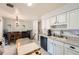 Bright kitchen with white cabinetry, tile floors, and access to the dining room at 15341 E Arkansas Pl, Aurora, CO 80017