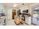 Functional kitchen with white cabinetry, stainless appliances, kitchen cart and view to outside patio at 15341 E Arkansas Pl, Aurora, CO 80017