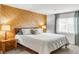 Bedroom featuring a wooden accent wall, neutral paint, and large window for lots of natural light at 5374 W Canyon Trl # B, Littleton, CO 80128