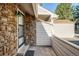 Exterior of house showing stone veneer, white vinyl siding, and black trim door with a dark doormat at 5374 W Canyon Trl # B, Littleton, CO 80128