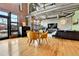 Open living room with hardwood floors, exposed brick, a fireplace, and large windows at 1860 N Washington St # 212, Denver, CO 80203