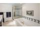 Bright bathroom featuring a garden tub, tiled accents, and glass enclosed shower stall at 7844 S Eudora Cir, Centennial, CO 80122
