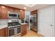 Updated kitchen with stainless steel appliances, warm wood cabinetry, and easy access to living areas at 7844 S Eudora Cir, Centennial, CO 80122