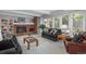 Cozy living room with a brick fireplace, built-in bookshelves, and large windows with backyard views at 7844 S Eudora Cir, Centennial, CO 80122