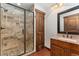 Bathroom features a tiled shower with a glass door, granite countertops, and a wood-framed mirror at 3048 Starling Ct, Castle Rock, CO 80109