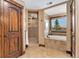 Luxurious bathroom featuring a soaking tub, walk-in shower, and a rustic wooden door and trim at 3048 Starling Ct, Castle Rock, CO 80109