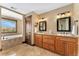 Well-appointed bathroom featuring a double vanity with granite countertops, a soaking tub, and stylish tile flooring at 3048 Starling Ct, Castle Rock, CO 80109