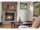 Cozy living room featuring a stone fireplace with a wooden mantel, a coffee table with seating, and natural light from the windows at 3048 Starling Ct, Castle Rock, CO 80109