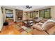 Cozy living room featuring a stone fireplace, hardwood floors, and comfortable seating with views of the outdoors at 3048 Starling Ct, Castle Rock, CO 80109