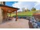 Cozy patio with an outdoor dining set and lounge chairs, all with a stone retaining wall and green hillside views at 3048 Starling Ct, Castle Rock, CO 80109