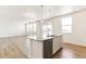 Bright kitchen featuring white cabinets, granite countertops, stainless steel appliances, and a center island with pendant lighting at 955 Tallus St, Lochbuie, CO 80603