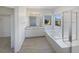 Bright bathroom with dual vanity sinks, a soaking tub, and a separate glass shower enclosure at 11933 W 83Rd Ln, Arvada, CO 80005