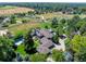 Wide aerial view of a large estate with a swimming pool, surrounded by green fields and mature trees at 5 Random Rd, Cherry Hills Village, CO 80113
