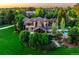 Aerial shot of a luxurious home with a pool, lush green lawns, and mature trees in a private setting at 5 Random Rd, Cherry Hills Village, CO 80113