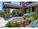 Inviting covered patio with stone fireplace and colorful landscaping, perfect for outdoor entertaining at 5 Random Rd, Cherry Hills Village, CO 80113