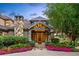 Charming front entrance with stone accents, manicured flowerbeds, and a well-lit porch at 5 Random Rd, Cherry Hills Village, CO 80113