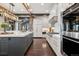A modern kitchen featuring high-end stainless steel appliances and sleek white cabinetry with gold hardware accents at 5 Random Rd, Cherry Hills Village, CO 80113