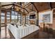 Spacious living room featuring a high vaulted ceiling, stone fireplace, large windows, and a large sectional sofa at 5 Random Rd, Cherry Hills Village, CO 80113