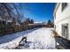 Spacious backyard with snow, lawnmower, and fence at 1621 Flemming Dr, Longmont, CO 80501