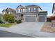 Two-story house with gray siding, stone accents, and a three-car garage at 7478 Oasis Dr, Castle Rock, CO 80108