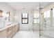 Luxury bathroom featuring marble walls, double vanity, walk-in shower, and soaking tub at 754 S York St, Denver, CO 80209