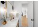 Chic powder room with stylish lighting, vanity, and views down long hall at 754 S York St, Denver, CO 80209