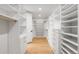 Spacious walk-in closet with custom white shelves and drawers, accented by wood floors, offers ample storage at 754 S York St, Denver, CO 80209