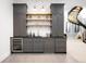 Stylish wet bar boasts gray cabinets, open shelving, and sleek fixtures next to a spiral staircase at 754 S York St, Denver, CO 80209