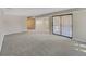 Open-concept living room with light carpet and sliding glass doors for access to outdoor space at 389 S Kalispell Way # C, Aurora, CO 80017