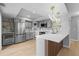 Modern kitchen with stainless steel appliances, gray cabinets, marble backsplash, and a center island at 13254 E Asbury Dr, Aurora, CO 80014