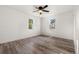 Spacious bedroom with neutral walls, laminate flooring, a ceiling fan, and plenty of natural light from two windows at 1636 Geneva St, Aurora, CO 80010