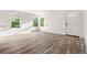 Open living space featuring laminate flooring, white walls, and natural light from dual windows at 1636 Geneva St, Aurora, CO 80010